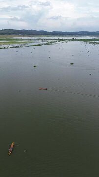 Drone Orbit Around Fisherman Boat on Rawa Pening Lake Beneath Majestic Mountains