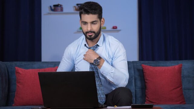 A bearded young man discussing a sales report on a video call with his colleagues. Handsome businessman in formals using his laptop to make a web call - online meeting  distant communication  remot...
