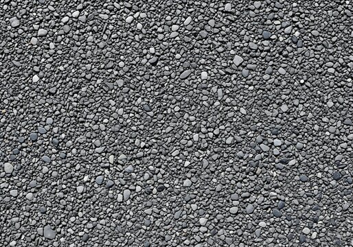 Topdown view of a textured surface covered in small grey pebbles and gravel