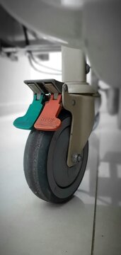 Close up of adjustable caster wheel with locking system installed on patient bed in hospital, 