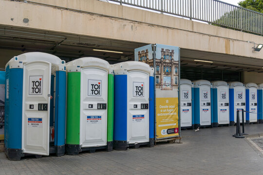 Fila de aseos port&aacute;tiles de pl&aacute;stico azul, blanco y verde de la marca Toi Toi, situados provisionalmente para uso p&uacute;blico en la terminal de la Estaci&oacute;n del Nord de Barcelona en mayo de 2026.