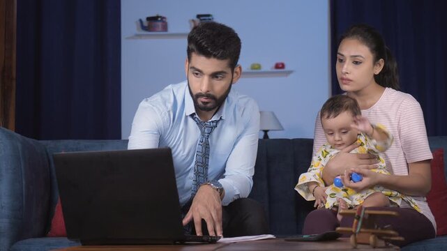 A young executing filling form for the new mother - working on a laptop  work from home. An attractive Indian mother holding a cute baby girl on her lap - parent-child bonding  comfortable  relaxat...
