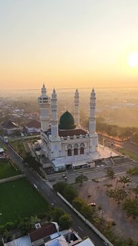 Aerial Drone View of Grand Mosque with Green Dome and Four Minarets at Sunset in Indonesia