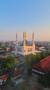 Aerial Drone View of Grand Mosque with Green Dome and Four Minarets at Sunset in Indonesia