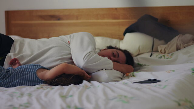 Mother and toddler sleeping together in bed at home, peaceful family moment showing comfort, protection, emotional security, and deep bonding during rest and quiet nighttime routine