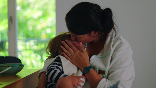 Mother comforting toddler after fall while holding and kissing head, emotional family moment showing protection, reassurance, care, and strong maternal bond during distress