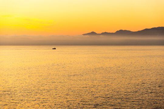 silhouette of fishing boat on walker bay, coastline of DeKelders, South Africa