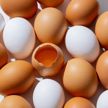 Huevos frescos blancos y caf&eacute;s con cascar&oacute;n roto