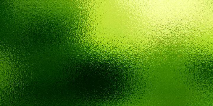 Green beer in a glass with bubbles and foam on a wet green textured background