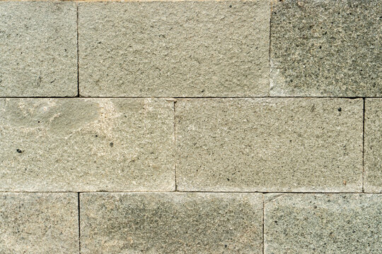 Texture of natural andesite stone, with its distinctive grayish-green color and grainy texture, is well-organized on exterior walls and floors due to its durability.