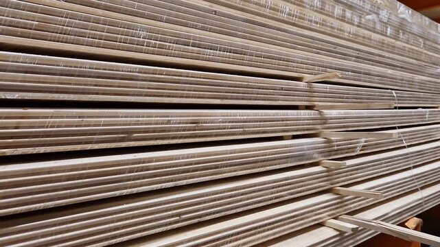 Wooden lining made of softwood in bundles. A stack of wooden panels (lining) made of natural softwood, packed in transparent film. Building materials for finishing walls and ceilings in a warehouse