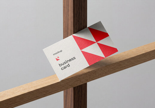 Business card mockup leaning on a geometric wooden structure frame isolated against a gray background
