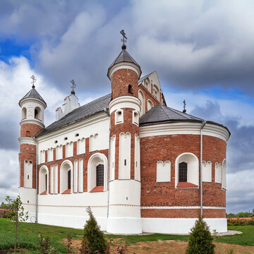 Fortified church apside in Murovanka, Belarus. Three quarter rear view of gothic defense architecture under cloudy sky