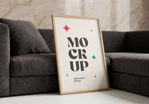 Front view of a vertical wooden framed poster mockup hanging on a luxury beige marble wall next to a glowing geometric pendant lamp