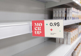 Close-up perspective view of a supermarket shelf price tag mockup in a clear plastic holder on an empty white store shelf with blurred products in the background