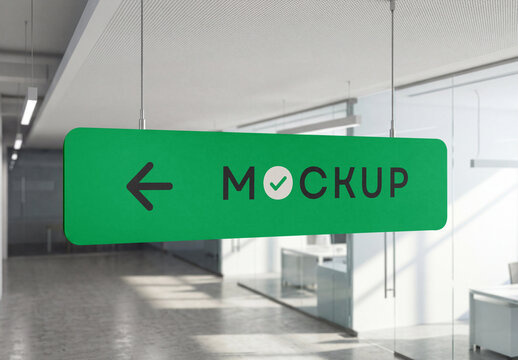 Perspective view of a horizontal green ceiling-hung directional signage mockup suspended by steel cables in a modern office corridor