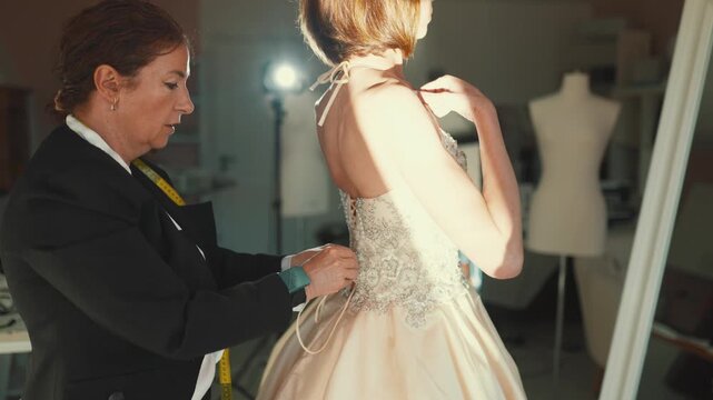 Professional dressmaker lacing up wedding dress bodice