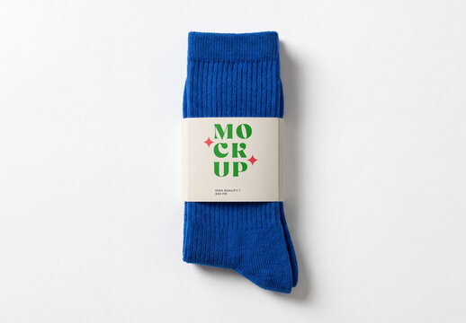 Top view of a pair of blue ribbed cotton socks mockup with a paper label packaging band isolated on a solid white background