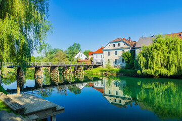 Obraz premium Bridge over Krka river in medieval small town Kostanjevica na Krki in Slovenia