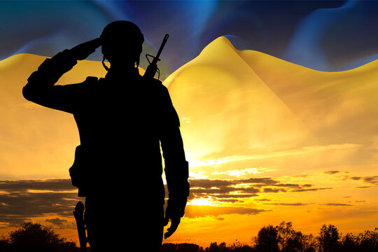 Silhouette of a soldier against the sunset with Ukraine flag. Armed forces of Ukraine concept