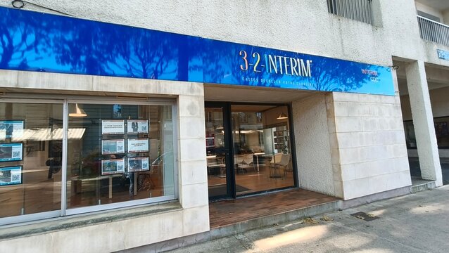 Saintes, France - April 21, 2026: Saintes. 3-2 Interim office building exterior with large blue sign and glass entrance, showcasing recruitment services in a modern urban setting