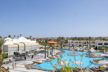 Fototapeta premium A luxury resort swimming pool with palm trees modern architecture and elegant holiday accommodation in Sharm El Sheikh Egypt on a hot sunny summers day