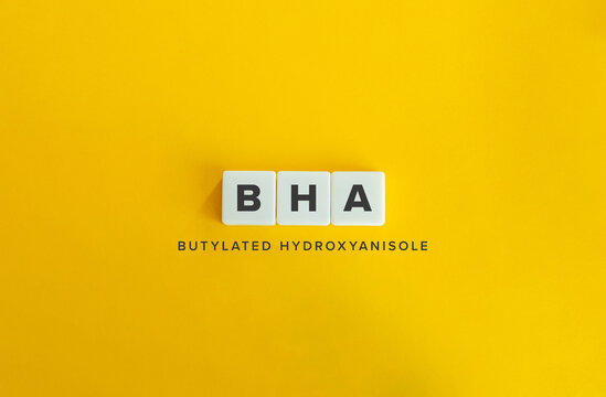 BHA Butylated Hydroxyanisole Acronym on White Tiles Against Bright Yellow Background