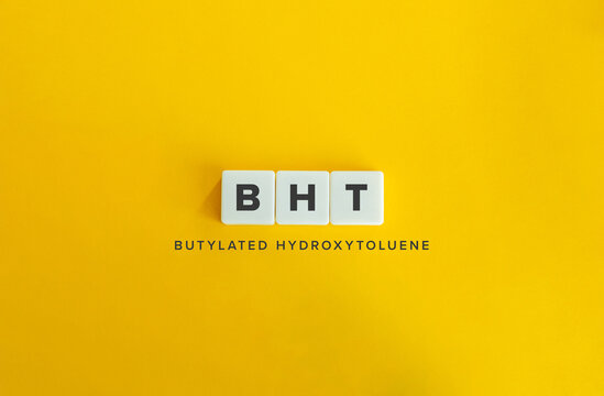 BHT Butylated Hydroxytoluene Acronym on White Tiles Against Bright Yellow Background
