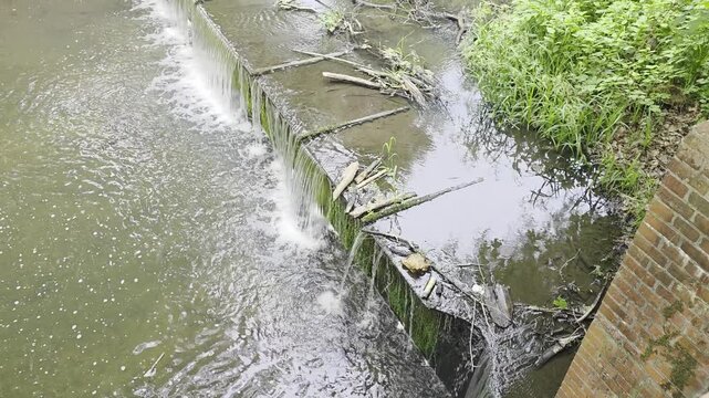 water flowing into the river 
wycieczka na rowerze nad wodą przy tamie
a bike trip along the water at the dam