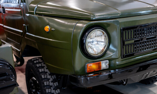 Close-up of round headlights of a green military vehicle. Historical vehicle. Round headlight of a green vintage military vehicle.