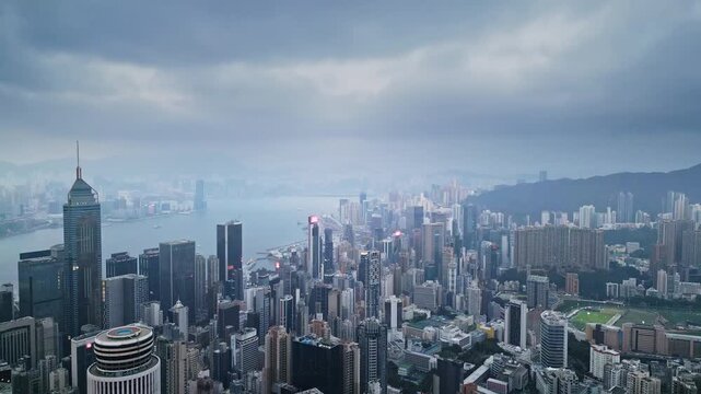 Wide aerial panorama of metropolis near harbour and islands at cloudy time. Expansive bay and ferry routes define urban edge. Tourism and citybranding backdrop with broad vantage for campaigns