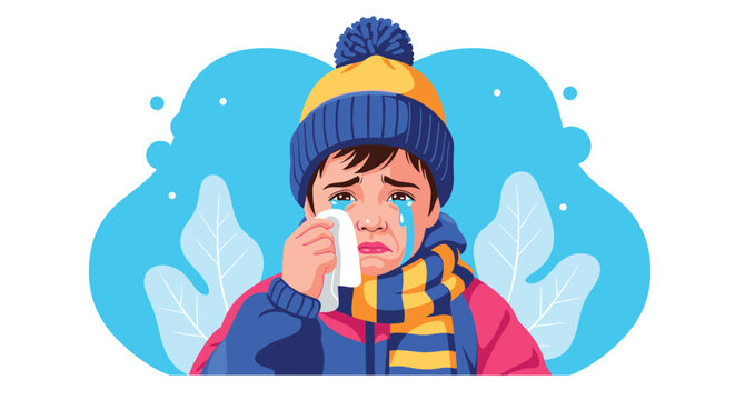 Sad little boy wearing a blue winter hat and striped scarf cries and wipes his eyes with a tissue on a blue background.