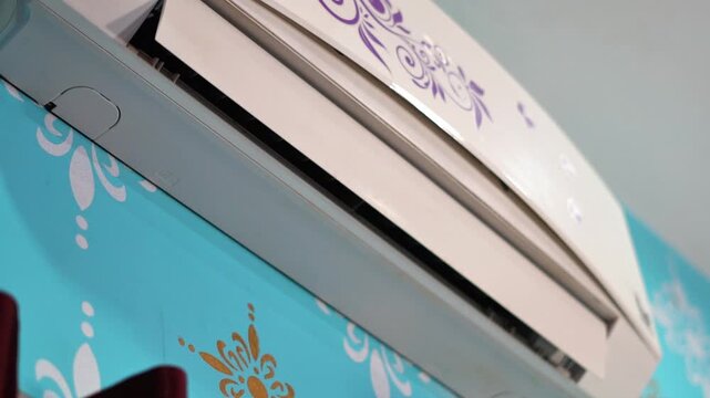 Modern Air Conditioner Switch On and Cool Air on Colorful Wallpaper Wall.