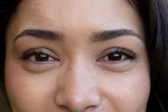 African American woman gazing in tight close-up at studio, showing eyelashes and skin texture