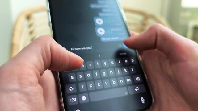 Hands type on a smartphone chat screen in close up. The message grows as fingers tap the mobile keyboard. Digital messaging and social app communication concept..