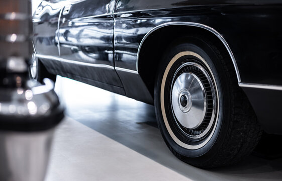 Close-up of the front part of the old retro car. Fender and the front wheel of the car. Side view. Selective focus. A close up of wheel disk and the side of a vintage automobile