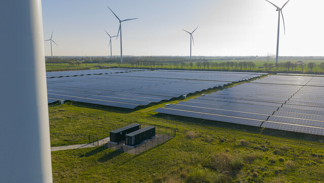 Aerial drone view of renewable battery storage at a solar park, balancing the grid and preventing net congestion in The Netherlands.