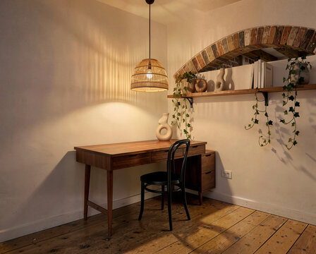 Cozy wooden desk with chair under woven pendant light in rustic home office corner