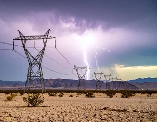 Dramatic lightning strike illuminates a line of highvoltage power towers across a vast, cracked desert landscape, symbolizing the raw power of nature and human energy grid infrastructure. © SolaruS