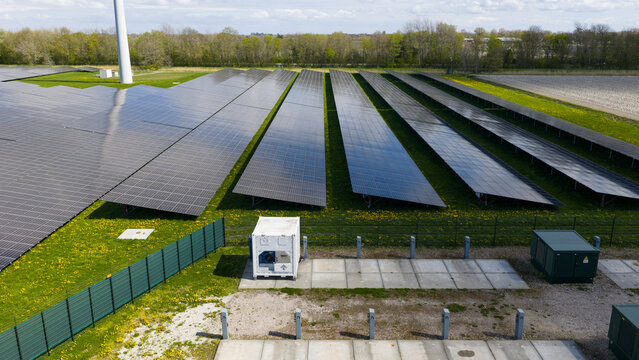 Aerial drone view of renewable battery storage at a solar park, balancing the grid and preventing net congestion in The Netherlands.