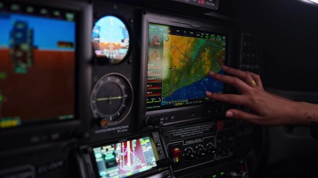 Pilot operating touch screen gps navigation system in cockpit
