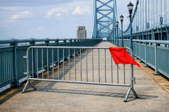 A metal barricade with a red flag, often used for construction or protest purposes