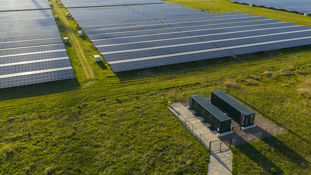 Aerial drone view of renewable battery storage at a solar park, balancing the grid and preventing net congestion in The Netherlands.