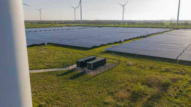 Aerial drone view of renewable battery storage at a solar park, balancing the grid and preventing net congestion in The Netherlands.