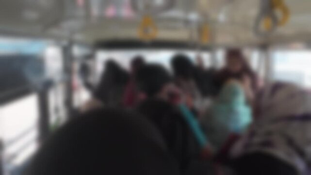 Indian women passengers leaving public bus in Hyderabad, India. Blurry view ofeveryday urban commute and traditional shopping culture. Street lifestyle bokeh footage for background.