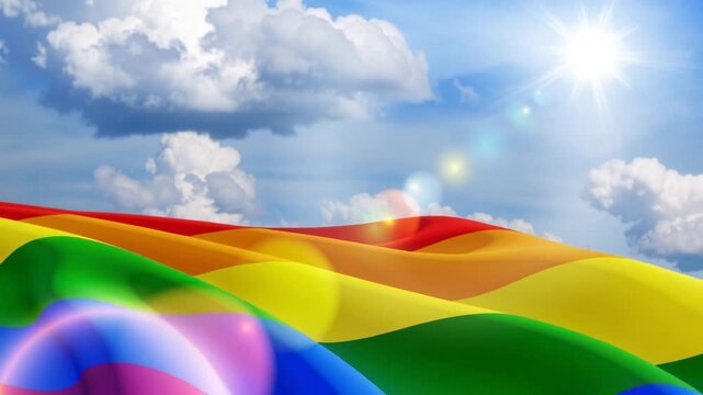 Waving LGBT pride flag on the blue sky, rainbow flag background. Multicolored peace flag movement. Original colors symbol.