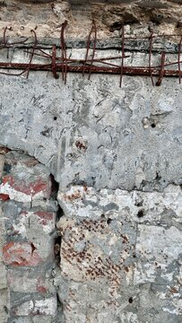 rusty rebar grid embedded in cracked concrete wall with copy space