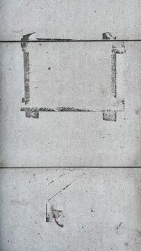 faint black stencil rectangle, a poster print mark on light gray concrete wall with copy space