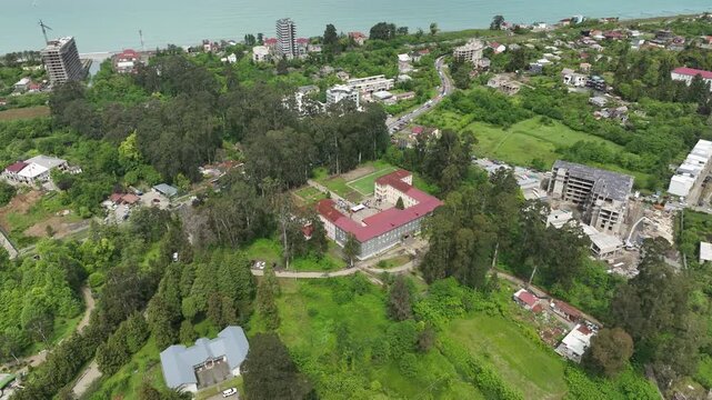 Chakvi, Georgia &mdash; May 22 2026: Aerial drone view of Public School N1 building complex surrounded by lush green trees and coastal landscape in Adjara region.