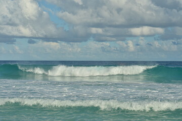 Obraz premium Turquoise sea and gentle waves at a sunlit beach